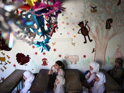 Syrian school girls sit at their classroom at the Saif al-Dawla school as they take part i