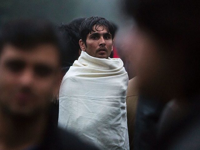 A migrant looks on as he wears a blanket on him during the evacuation of the Jardin d'Eole migrants camp, in Paris on June 6, 2016. The Jardin d'Eole, where more than a thousand people were installed for several weeks has been evacuated peacefully on June 6, 2016. / AFP …