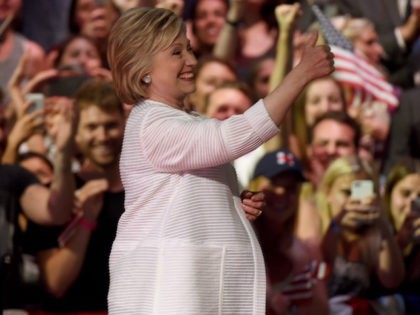 TOPSHOT - Democratic presidential candidate Hillary Clinton acknowledges celebratory cheer
