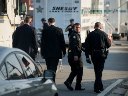 City of Orlando Police Chief John Mina (second from R) walks with law enforcement official