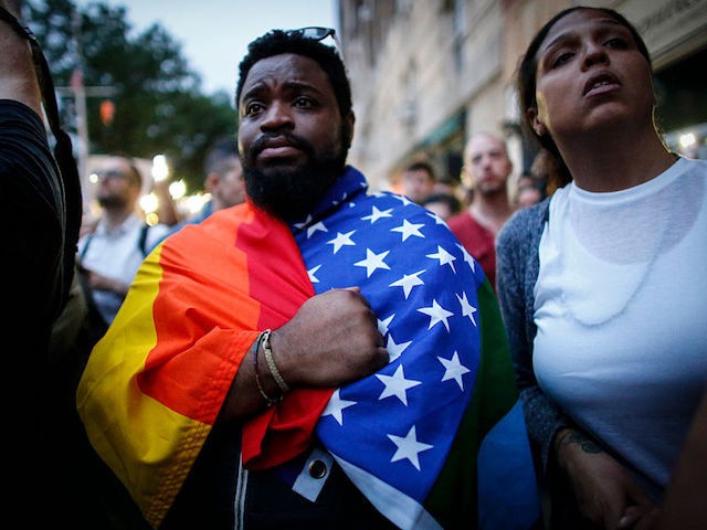 A man holds a flag during a vigil in solidarity for the victims killed at Pulse nightclub