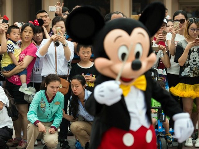 People take pictures of Mickey Mouse (in foreground) after the opening ceremony of the Shanghai Disney Resort in Shanghai on June 16, 2016.