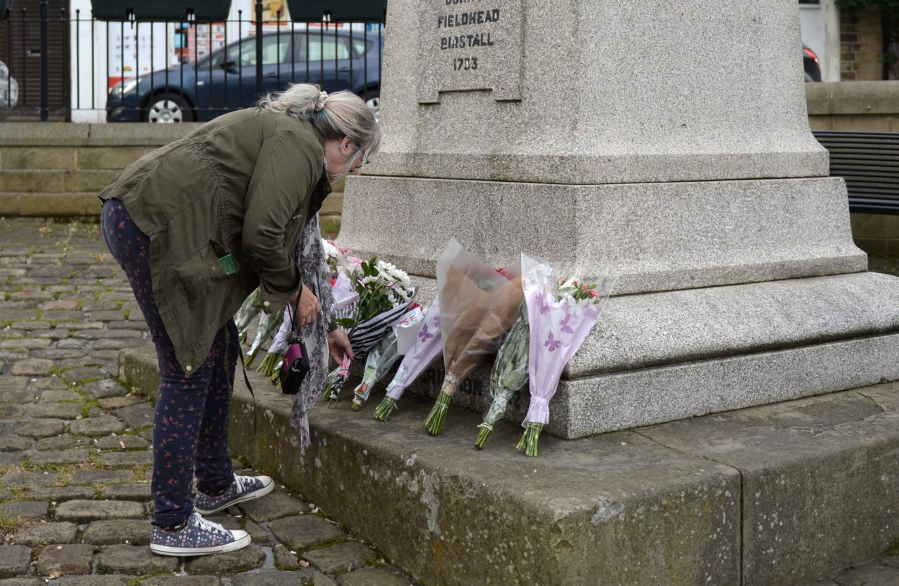 A woman lays flowers at a statue to Joseph Priestly in Birstall near to the scene where Labour MP Jo Cox was shot on June 16, 2016. A British lawmaker died today after a shock daylight street attack, throwing campaigning for the referendum on Britain's membership of the European Union into disarray just a week before the crucial vote. / AFP / OLI SCARFF (Photo credit should read OLI SCARFF/AFP/Getty Images)