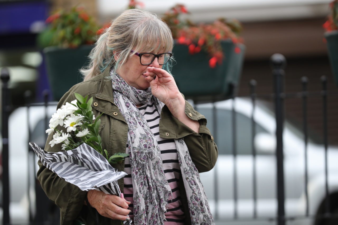 BIRSTALL, ENGLAND - JUNE 16: People arrive with floral tributes after the murder of Jo Cox, 41, Labour MP for Batley and Spen, who was shot and stabbed by an attacker at her constituicency on June 16, 2016 in Birstall, England. A man also suffered slight injuries during the attack. Jo Cox has died after being shot and repeatedly stabbed while holding her weekly surgery at Birstall Library, Birstall near Leeds. A 53-year old man has been arrested in connection with the crime. (Photo by Christopher Furlong/Getty Images)