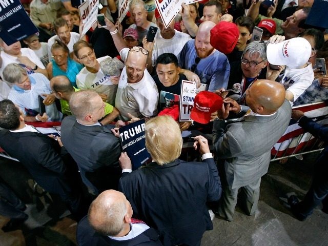 Republican presidential candidate Donald Trump (C) greets supporters following a campaign