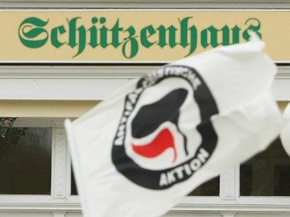 POESSNECK, GERMANY - MARCH 28: A protester waves a flag of the Antifa, or Antifaschistische Aktion ('anti-fascist action') as demostrators march past the 'Schuetzenhaus,' literally 'Clubhouse,' during an anti-Nazi rally on March 28, 2009 in Poessneck, Germany.