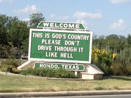 Highway sign in Hondo, Texas, that reads "This is God's country, please don't drive through it like hell."