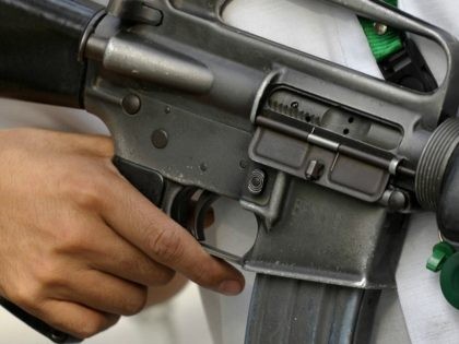 A security guard armed with an M-16 rifle secures the gates of the Philippine Department o