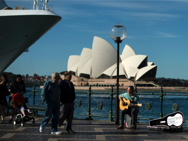 A man plays a song on a guitar on the Sydney Harbour in front of iconic Opera House on May 11, 2016. Australia's jobless rate was at 5.7 percent in March, but is forecast by the government in its annual national budget unveiled last week to fall to 5.5 percent …