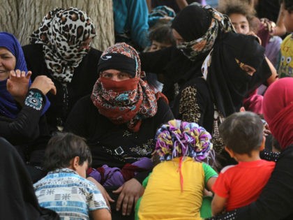 Displaced Iraqis, who fled the al-Falahat village west of Fallujah due to fighting between Iraqi government forces and the Islamic State (IS) group, wait to receive food and aid at the village of al-Azraqiyah, on June 4, 2016. Iraqi pro-government forces, made up of fighters from the army, the police …