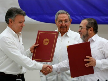 Colombian President Juan Manuel Santos, left, and Commander of the Revolutionary Armed Forces of Colombia or FARC, Timoleon Jimenez, right, shake hands during a signing ceremony of a cease-fire and rebel disarmament deal, in Havana, Cuba, Thursday, June 23, 2016. The deal moves Colombia closer to ending a 52-year war …