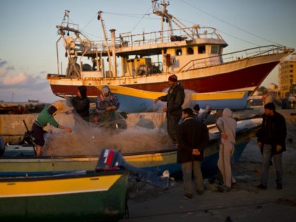 Palestinian fishermen pull their nets as they collect fish at the seaport in Gaza city on January 11, 2015. Around 4,000 fishermen work in Gaza, but more than half live below the poverty line.