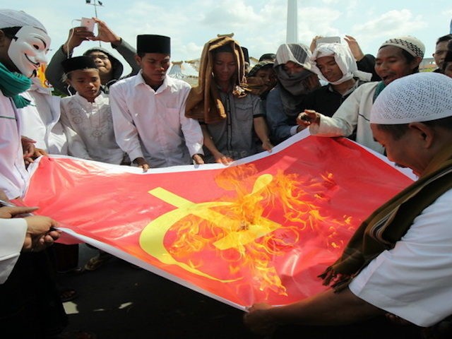 Massa dari Front Pembela Islam (FPI) dan Front Pancasila membakar kain bersimbol komunis d
