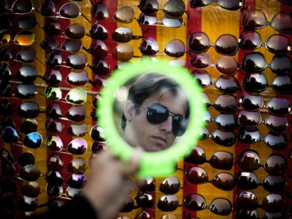 A Pakistani customer looks in a mirror as he shops for a pair of sun glasses at a vendor at the roadside in Islamabad, Pakistan, Wednesday, March 9, 2016. (AP Photo/B.K. Bangash)