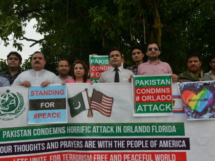 Pakistani civil society activists carry placards during a vigil for the victims of the Orl