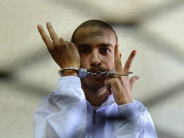 Egyptian Copt Albert Saber, 27, flashes the V for 'victory' sign from inside the