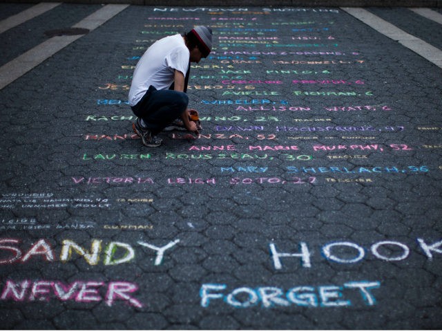 Street artist Mark Panzarino, 41, prepares a memorial as he writes the names of the Sandy Hook Elementary School victims during the six-month anniversary of the massacre, at Union Square in New York, June 14, 2013. REUTERS/Eduardo Munoz