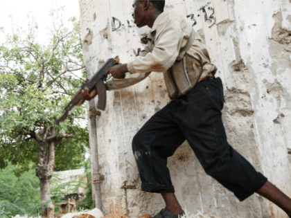 A fighter belonging to the Al-Shabab militias runs with his weapon during clashes with Som