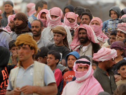 JORDAN, Royashed Town : Syrian refugees wait to cross to a camp at the Jordanian side of t