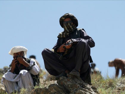 In this Friday, May 27, 2016 photo, Taliban fighters guard as senior leader of a breakaway faction of the Taliban Mullah Abdul Manan Niazi, not pictured, delivers a speech to his fighters, in Shindand district of Herat province, Afghanistan. In the rugged terrain of the Taliban heartland in southern Afghanistan, …