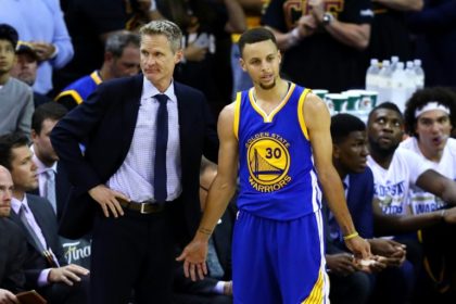 Steve Kerr of the Golden State Warriors (L) and Stephen Curry react in the second half against the Cleveland Cavaliers in Game 6 of the NBA Finals on June 16, 2016