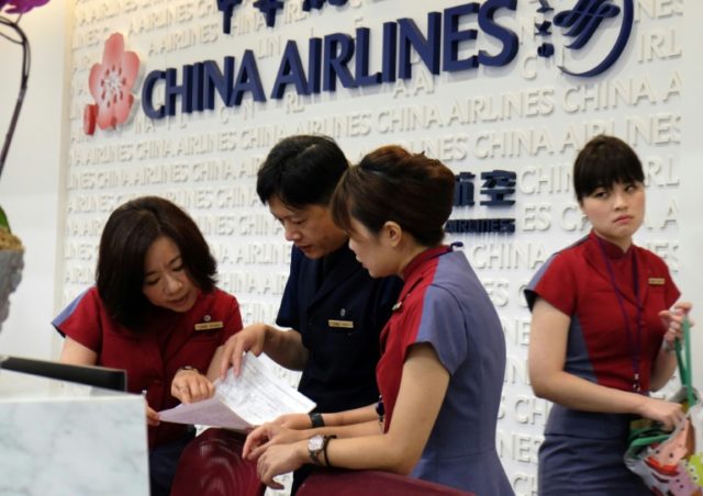 Ground staff of China Airlines check the latest information at the front desk during indus