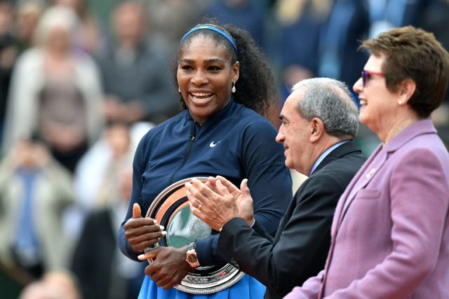 Serena Williams (L) stands with her 2016 French Open runner-up trophy next to former US te