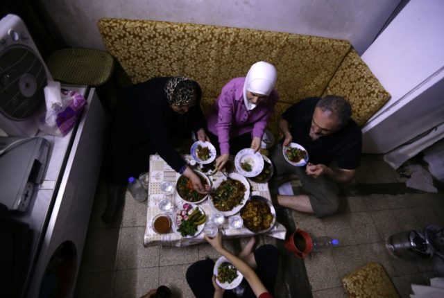 Syrian Rida Saleh (R) and his family, who fled rebel-held Eastern Ghouta, break their fast