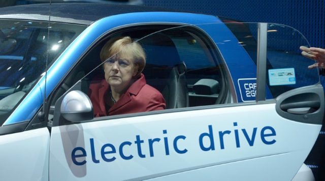 German Chancellor Angela Merkel sits in an electric car at the Daimler subsidiary car2go b
