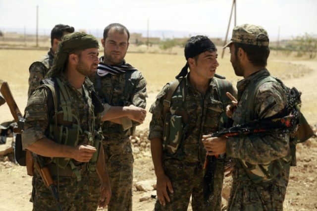 Fighters from the Syrian Democratic Forces (SDF) gather on the outskirts of the northern S