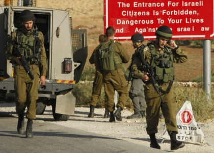 Israeli soldiers are seen at one of the entrances of the Palestinian village of Yatta in the occupied West Bank on June 9, 2016