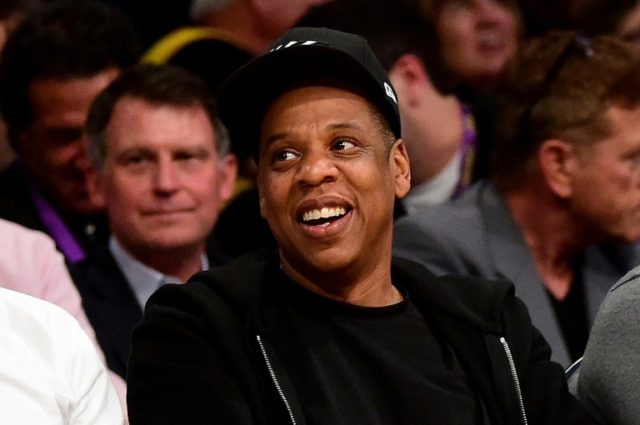 Jay-Z smiles as he sits courtside as the Los Angeles Lakers take on the Utah Jazz at Stapl