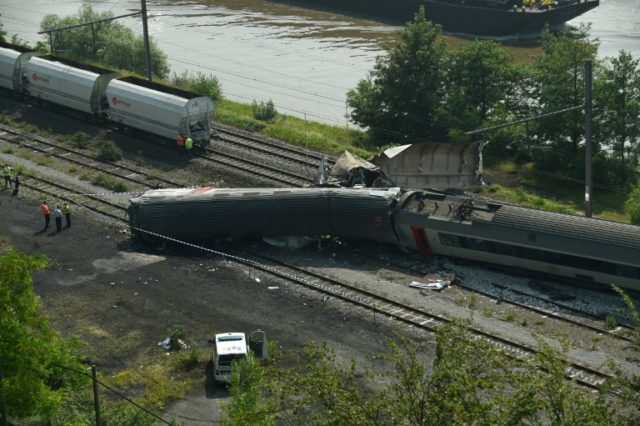 Damaged carriages lie on the track following a collision between a goods train and a passe