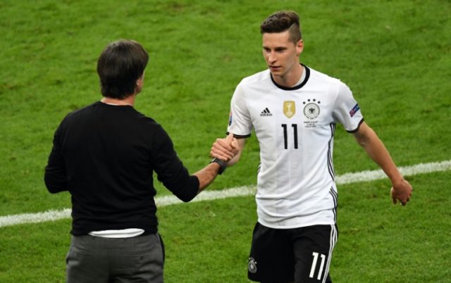 Germany midfielder Julian Draxler (R) shakes hands with coach Joachim Loew as he is substi