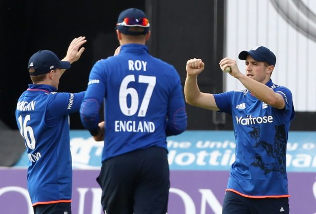 England captain Eoin Morgan (L) celebrates a catch with Chris Woakes (R) during play in th