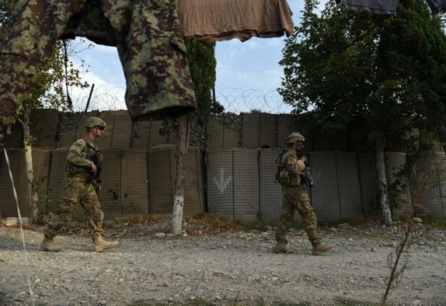 US army soldiers walk past an Afghan National Army (ANA) base in the Khogyani district in