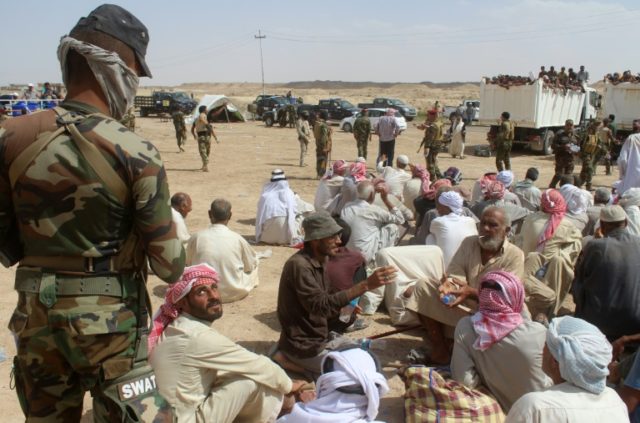 Displaced Iraqis who have been evacuated from their villages by government forces south of