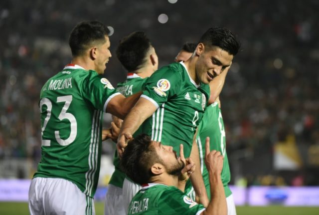 Mexico's Oribe Peralta (kneeling) prays next to teammate Raul Jimenez after scoring agains