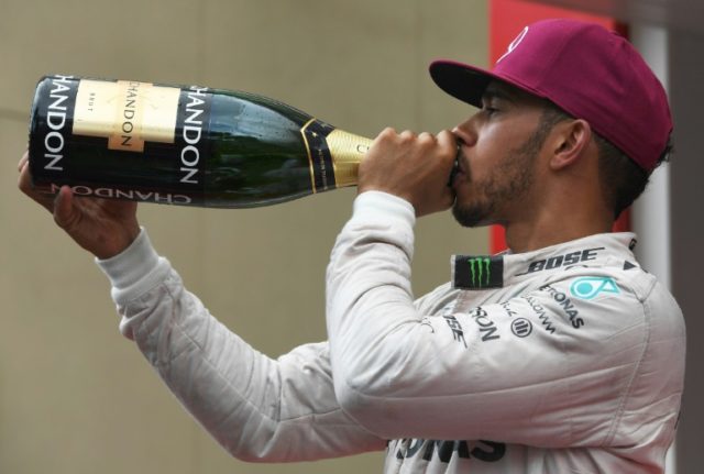 Mercedes AMG Petronas F1 Team's British driver Lewis Hamilton celebrates on the podium at