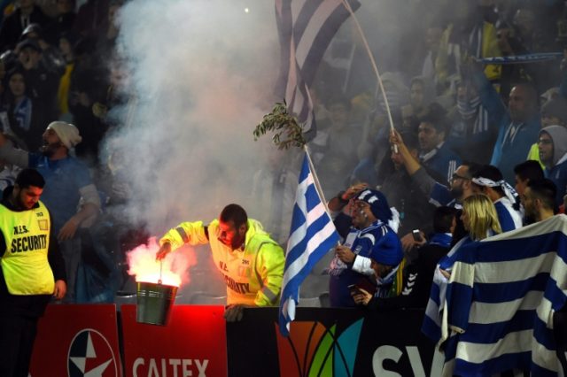 A security officer removes a flare during a international friendly football match between