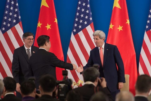 China's President Xi Jinping shakes hands with US Secretary of State John Kerry (R) as US