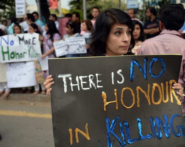 Pakistani human rights activists hold placards during a protest against honour killing in