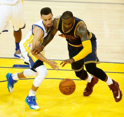 Golden State Warriors guard Stephen Curry (left) and Cleveland Cavaliers forward LeBron James scramble for a loose ball during game 1 of the NBA Finals on June 2, 2016 in Oakland, California