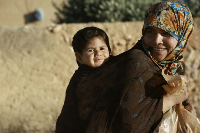 A Syrian woman and her child on the outskirts of the northern Syrian town of Manbij held b