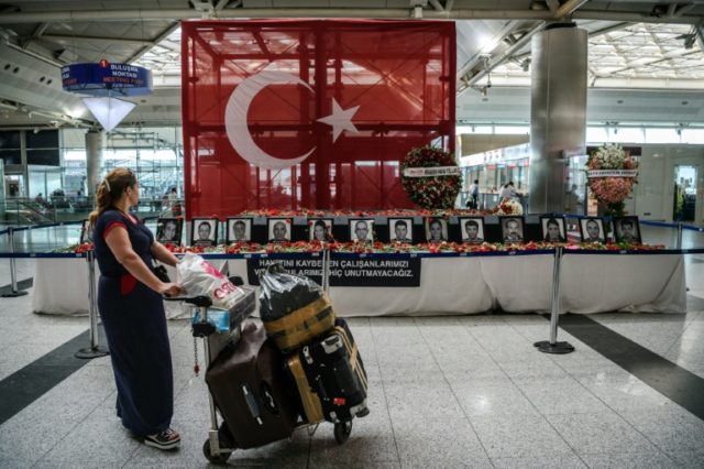 A passenger looks at the pictures of airport employees killed in the attack at Ataturk air