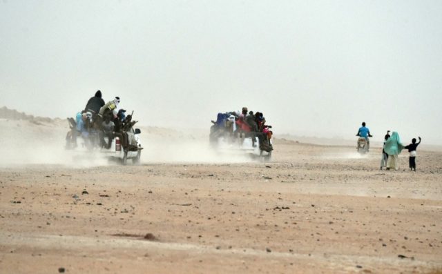 Migrants on pick-up trucks leave the outskirts of Agadez, Niger, heading across the Niger