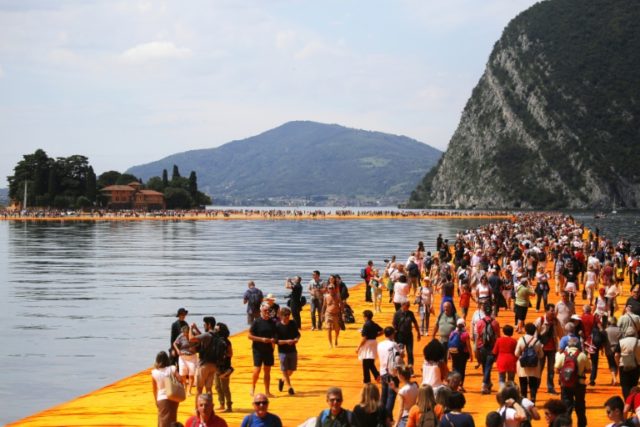 People walk on the monumental installation entitled 'The Floating Piers' created by artist