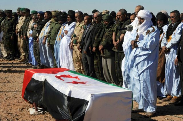 Mourners and members of the Sahrawi People's Liberation Army pray next to the coffin of Po