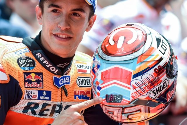 Honda's Spanish rider Marc Marquez shows a sticker on his helmet as a tribute for Luis Sal