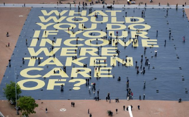 A giant poster promoting the basic income for all initiative in Switzerland was laid out i